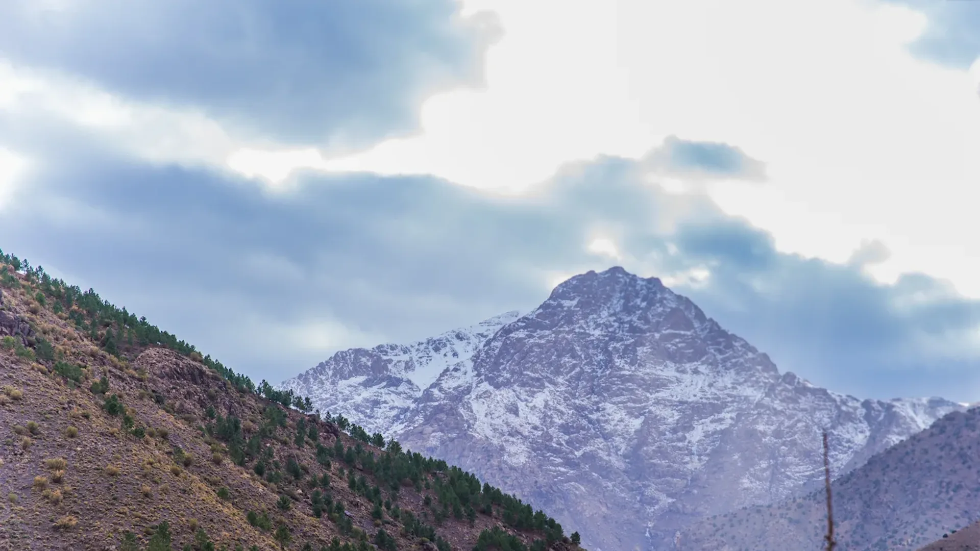 Snow-capped High Atlas mountains above a green spring valley in Morocco