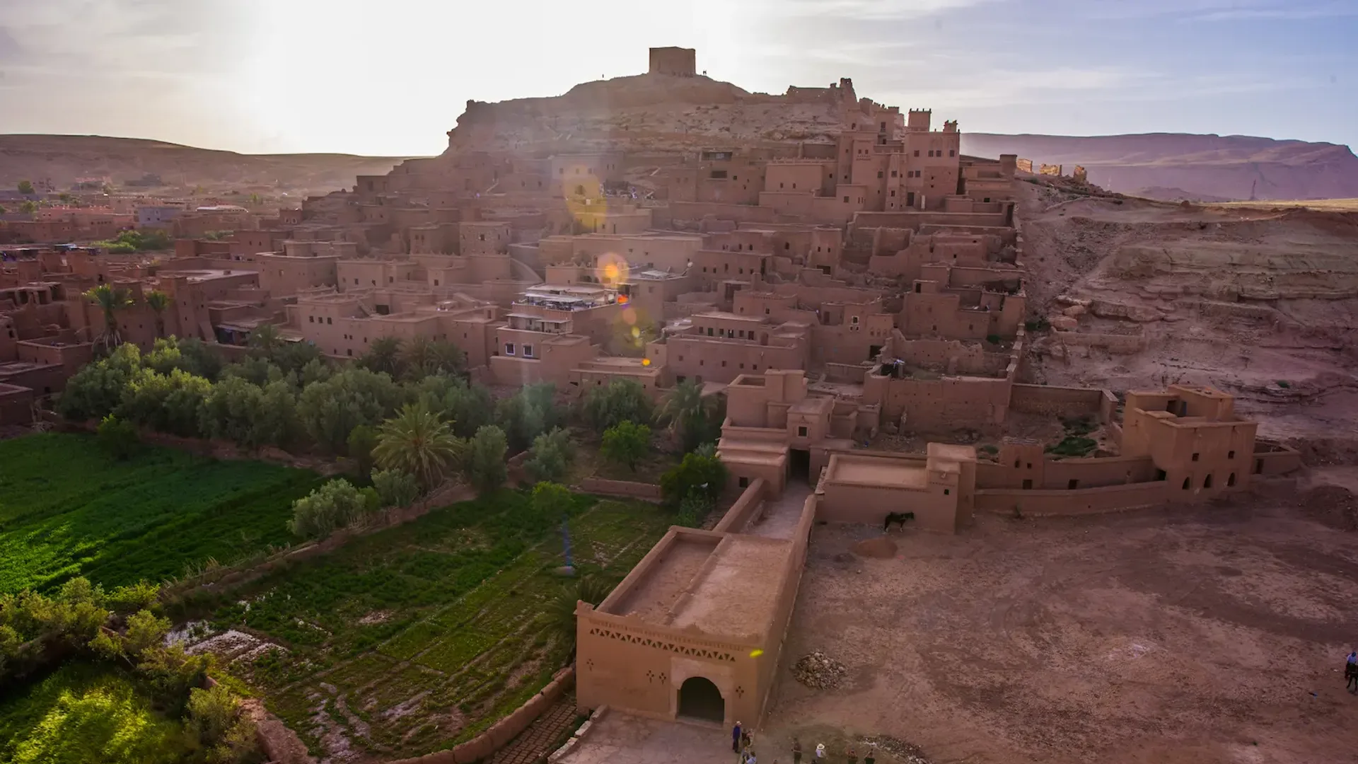 Ait Benhaddou ksar glowing red in morning light with the Ounila river crossing in the foreground